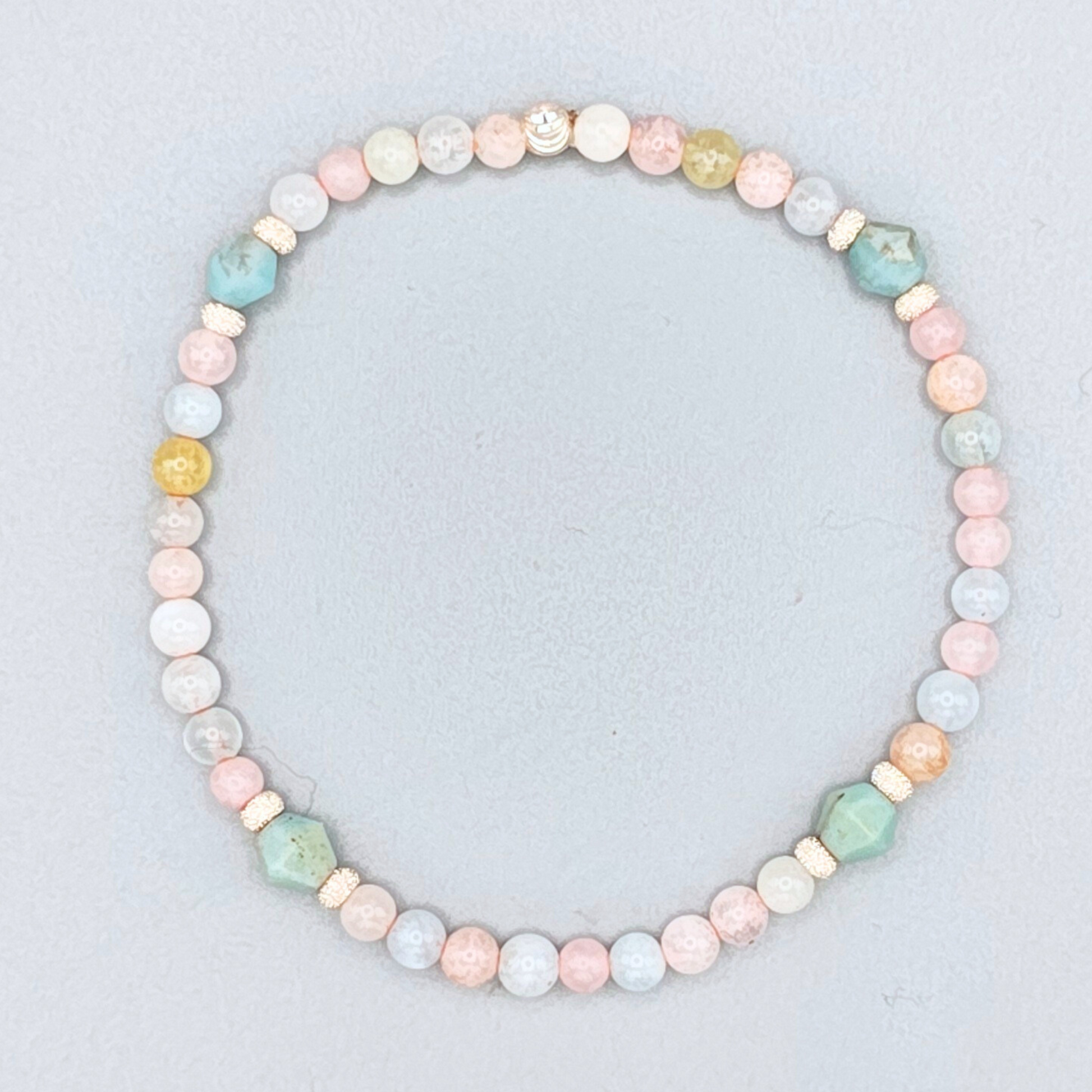 Pastel beaded necklace on a light gray background