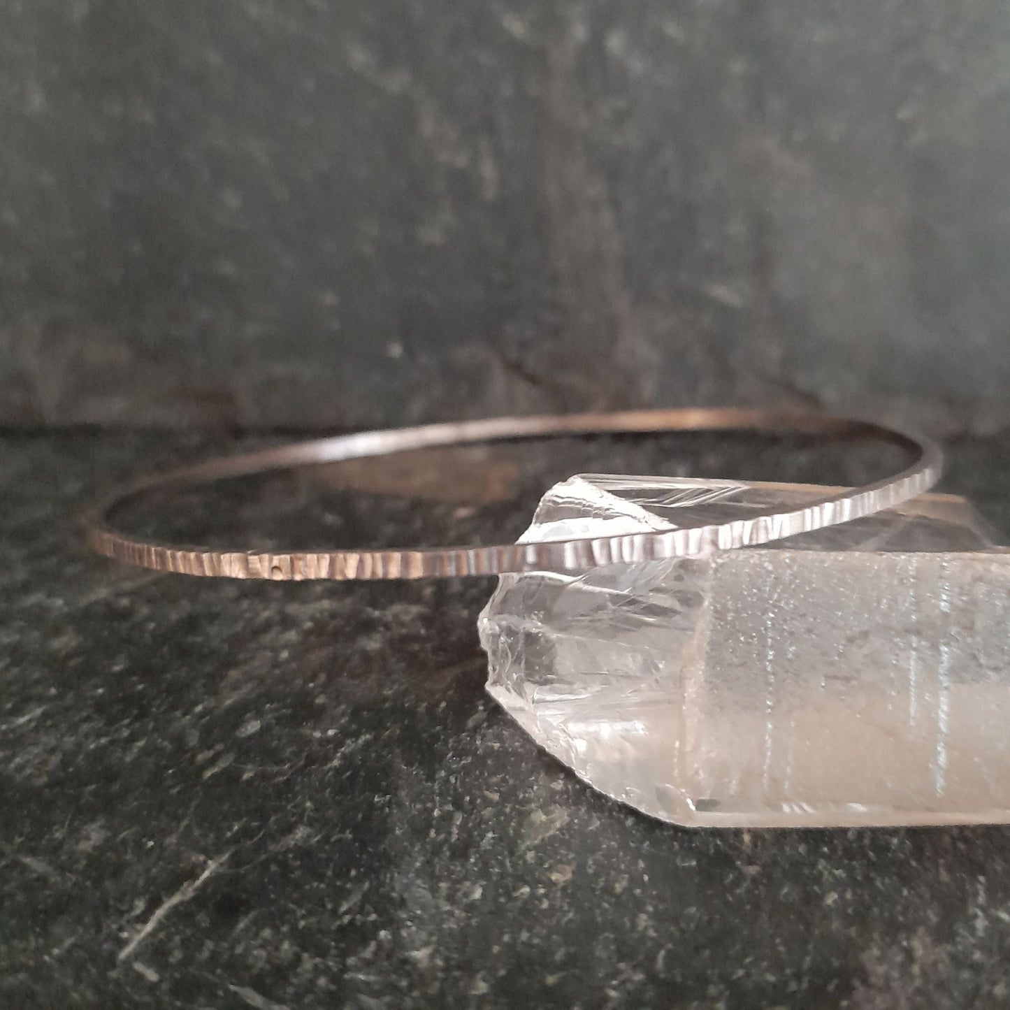 image shows a 1.5mm wide sterling silver bangle with hammered line detail